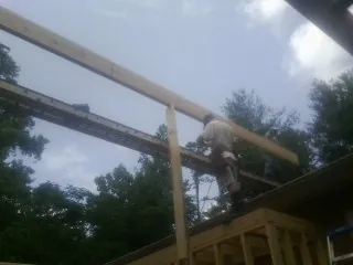 Carpenter setting a ridge beam over a new addition frame — Ice Dam Removal by Roofing Brothers in Stony Point